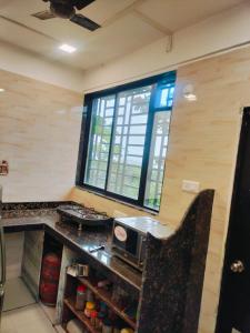 a kitchen with a counter with a microwave and a window at Golden Gate Retreats in karanja