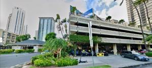 a building with a car parked in a parking lot at *RareLayout*2Qn Beds*Great for Groups,Friends,Wakiki in Honolulu