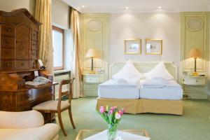 a hotel room with two beds and a desk at Central-Hotel Kaiserhof in Hannover