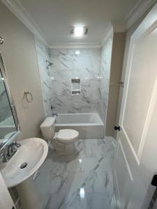 a bathroom with a white tub and a toilet and a sink at Downtown Baton Rouge 7BR Haven in Baton Rouge +76 photos