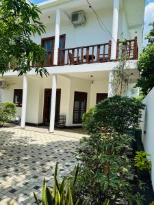 Un edificio blanco con balcón y patio. en Secret Mirage, en Mirissa