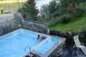 two people in a swimming pool with a view of a lake at Haus Andreas - Ferienwohnungen in Turracher Hohe