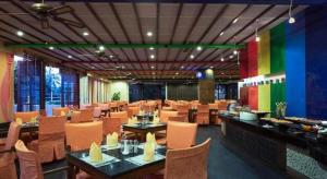 a restaurant with tables and chairs and colorful walls at International Asia-Pacific Convention Center in Sanya