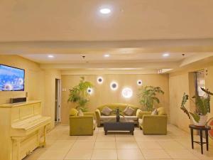 a living room with a couch and a piano at Stone House Hotel Pasay in Manila