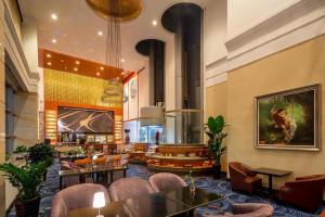 a lobby of a hotel with tables and chairs at Qingdao Blue Horizon Hotel Huangdao in Huangdao