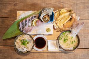 a wooden table topped with different types of food at 古民家ゲストハウス -Yokado Kirikushi- 穏やかな余暇を瀬戸内の島で in Etajima +32 photos
