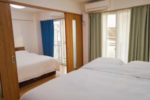 a bedroom with two beds and a window at 位于新桥的2卧室公寓 in Tokyo