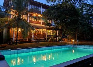 a swimming pool in front of a house at night at Verdant Hill Villa in Tangalle