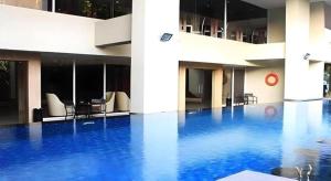 a swimming pool with blue water in a building at Arch Hotel Bogor in Bogor