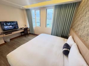 une chambre d'hôtel avec un lit et une télévision dans l'établissement Tc慢旅花蓮館-近東大門夜市市中心, à Hualien