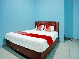 a bedroom with a bed with red and white pillows at Hotel O Adela in Laguboti +24 photos