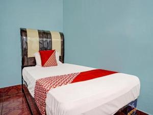 a bed in a room with a blue wall at Hotel O Adela in Laguboti