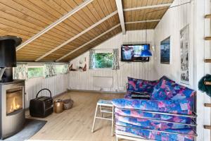 un salon avec un canapé et une cheminée dans l'établissement Charming Cottage Near The Water, à Kisserup