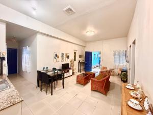a living room with a table and a dining room at Blue Summer Suites & Restaurant in Bingag