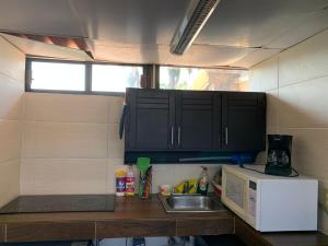 a small kitchen with a sink and a microwave at SUITE CLIMATIZADA Y EQUIPADA Zona Dorada Tuxtla in Tuxtla Gutiérrez