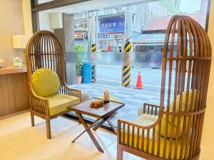 two chairs and a table in a room with a window at Tc慢旅花蓮館-近東大門夜市市中心 in Hualien City