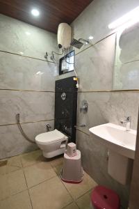 une salle de bains avec toilettes et lavabo dans l'établissement Basilica Residency, à Māvalli