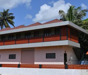 un bâtiment avec un toit rouge dans l'établissement Basilica Residency, à Māvalli