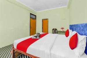 ein Schlafzimmer mit einem großen Bett mit rot-weißer Bettwäsche in der Unterkunft Hotel O ADORA STAY in Bheta