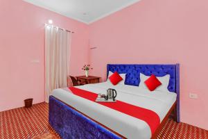 ein Schlafzimmer mit einem großen Bett mit roten Kissen in der Unterkunft Hotel O ADORA STAY in Bheta