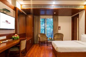 een hotelkamer met een bed, een bureau en een computer bij Hotel Grand FFOUR in New Delhi +47 foto's