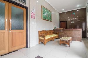 een kamer met een deur en een bank en een tafel bij RedDoorz near Tugu Bandara Sulthan Thaha Jambi in Sultan Thaha Airport