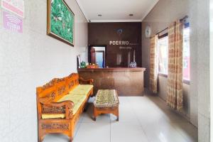 een kamer met een bank, een tafel en een toonbank bij RedDoorz near Tugu Bandara Sulthan Thaha Jambi in Sultan Thaha Airport
