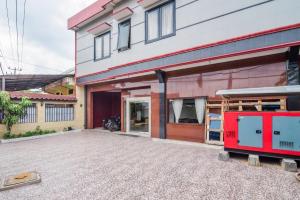 een rode brandweerwagen geparkeerd voor een gebouw bij RedDoorz near Tugu Bandara Sulthan Thaha Jambi in Sultan Thaha Airport