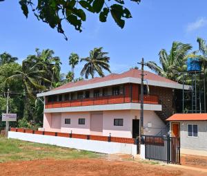 un bâtiment avec un toit rouge dans l'établissement Basilica Residency, à Māvalli