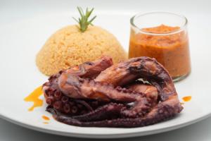 a plate of food with a octopus and a sandwich at Hotel Al Alba Hammam & Restaurant in Asilah