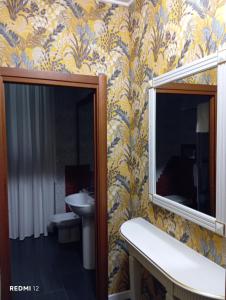 ein Badezimmer mit Waschbecken und Spiegel in der Unterkunft BF SUITE Foresteria Bellusci in Rho