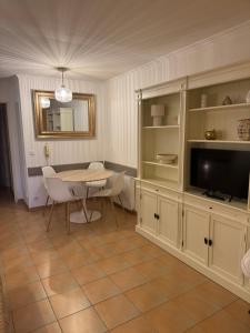 une salle à manger avec une table et une télévision dans l'établissement Le Papyrus -T2 Domaine Pierres et Vacances "Les Restanques du golf de Saint Tropez" à Grimaud, à Grimaud