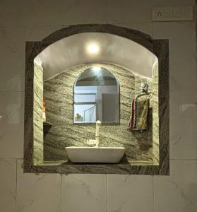 a bathroom sink with a mirror on a wall at Mato Shree Aashray Homestay in Gaya