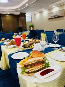 a table with a sandwich on a white plate at Moonlight Addis Hotel in Addis Ababa