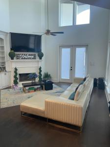 a living room with a large couch and a tv at Cute Home with some Razzle Dazzle in Baton Rouge