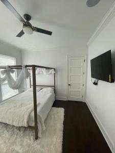 a bedroom with a bed and a flat screen tv at Cute Home with some Razzle Dazzle in Baton Rouge
