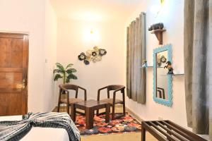 a bedroom with two chairs and a table at GR STAYs Private Pool Villa in Calangute 5 mins to Baga in Arpora +25 photos