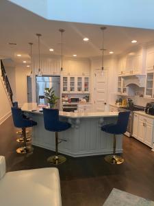 a kitchen with white cabinets and blue bar stools at Cute Home with some Razzle Dazzle in Baton Rouge