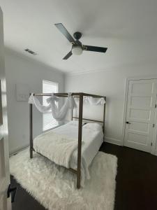a bedroom with a bed with a ceiling fan at Cute Home with some Razzle Dazzle in Baton Rouge +8 photos