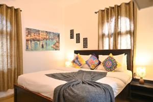 a bedroom with a bed with colorful pillows at GR STAYs Private Pool Villa in Calangute 5 mins to Baga in Arpora