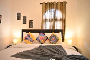a bedroom with a bed with pillows and a window at GR STAYs Private Pool Villa in Calangute 5 mins to Baga in Arpora