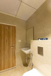 a bathroom with a sink and a wooden door at Hiwa Boutique Hotel in Hyderabad