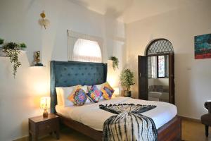 a bedroom with a bed with a black headboard at GR STAYs Private Pool Villa in Calangute 5 mins to Baga in Arpora