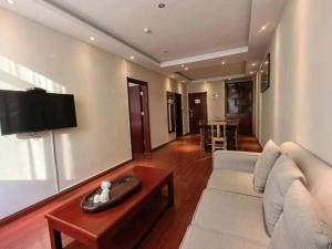 ein Wohnzimmer mit einer weißen Couch und einem Tisch in der Unterkunft GreenTree Inn ShanDong Yantai Yantai University Business Hotel in Yantai