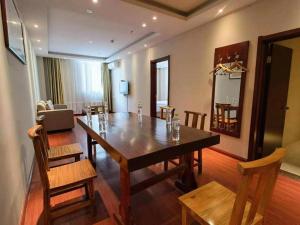ein Esszimmer mit einem großen Holztisch und Stühlen in der Unterkunft GreenTree Inn ShanDong Yantai Yantai University Business Hotel in Yantai