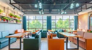 合肥市にあるJames Joyce Coffetel·Hefei Binhu Provincial Government Tangxihe Park Metro Stationのテーブルと椅子と窓のあるレストラン