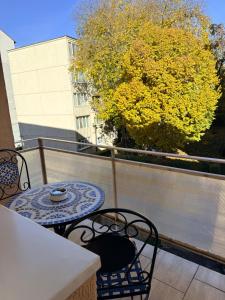ein Balkon mit Tisch und Stühlen und einem Baum in der Unterkunft Cozy Apartment 150 m from Târgu Mureș Hospital in Târgu Mureș + 2 Fotos
