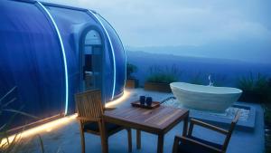 a bathroom with a tub and a sink and chairs at Arkaluna Resort & Adventure in Kintamani