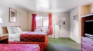 a hotel room with two beds and a flat screen tv at Econo Lodge Inn & Suites in Durango