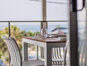 a table with two chairs and a wine glass on it at Humpback Villa in Kingscliff